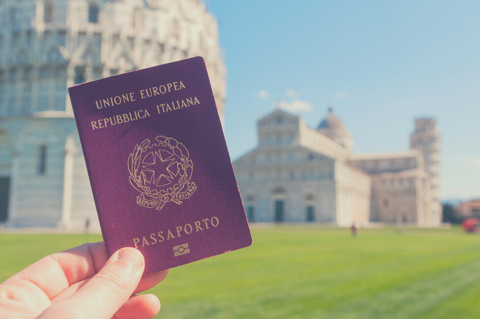 Man hold an italian passport in front of the world famous leaning tower of Pisa