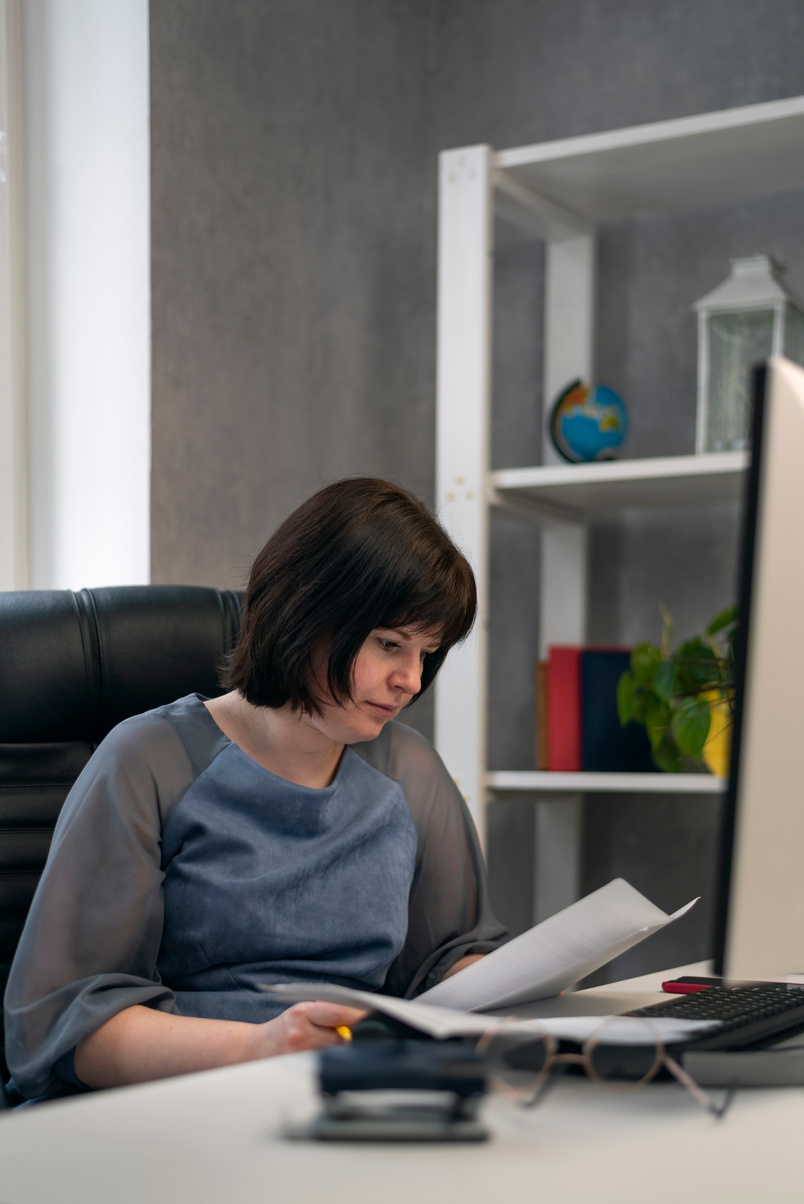 Woman Director in Office Works with Documents and Contracts. Employee Prepares Quarterly Report. Chief Checks Documents